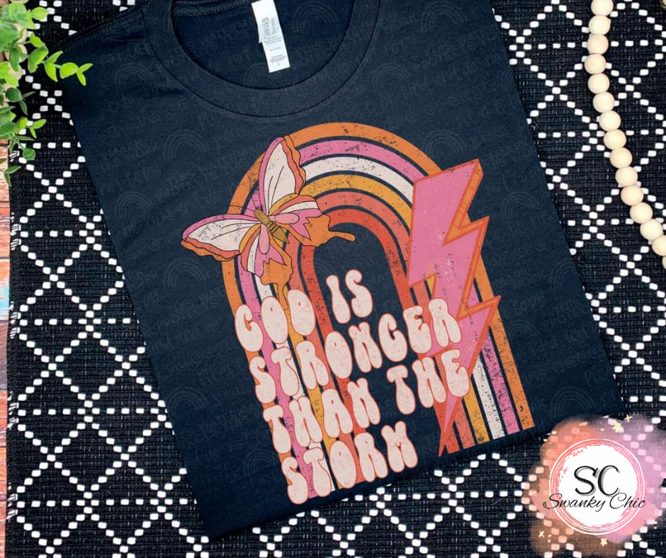 Kirsten Jutte — God is stronger than the storm: Small, tan, crewneck tee